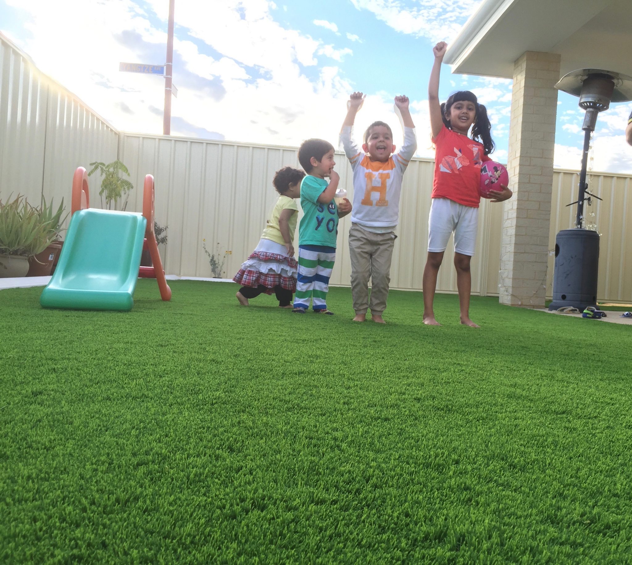 Kids playing on synthetic turf in back yard in Balcatta,Perth